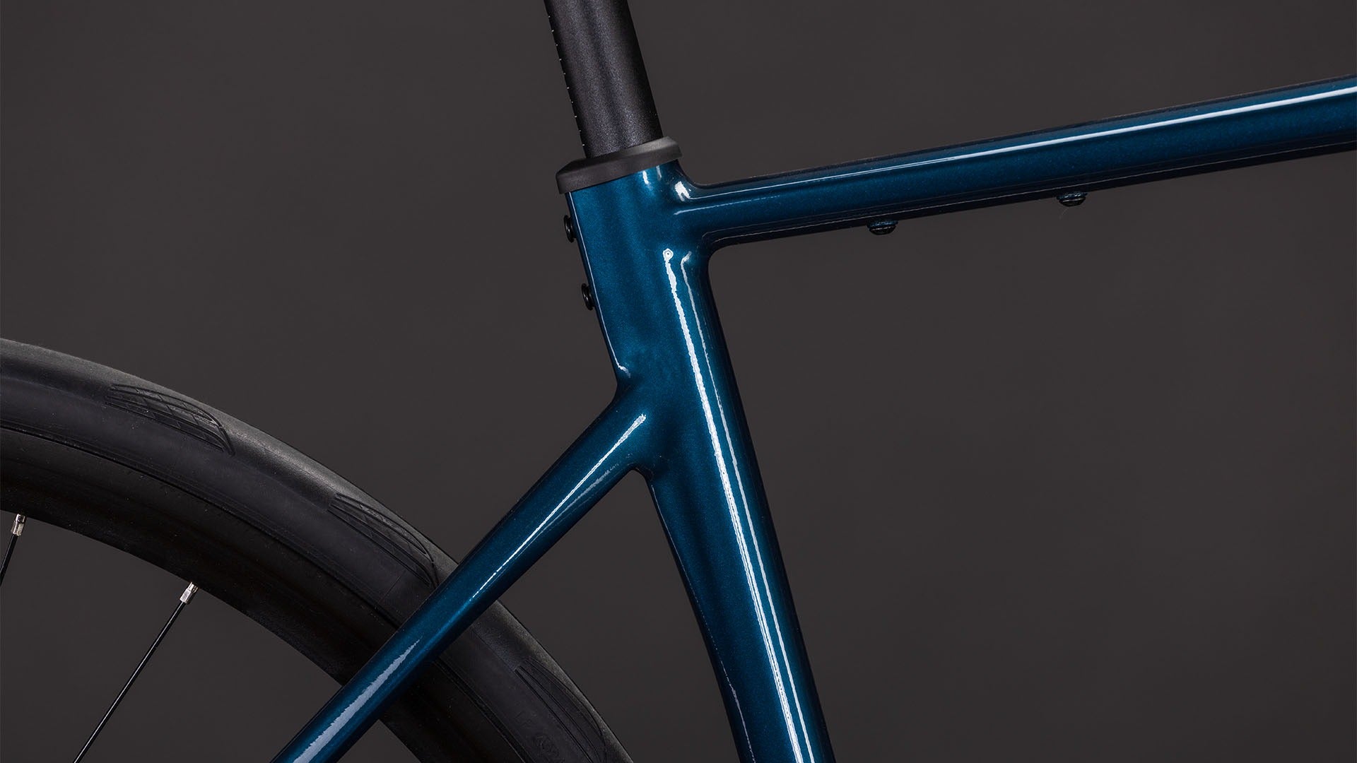 Close-up of a blue road bike frame on a dark background
