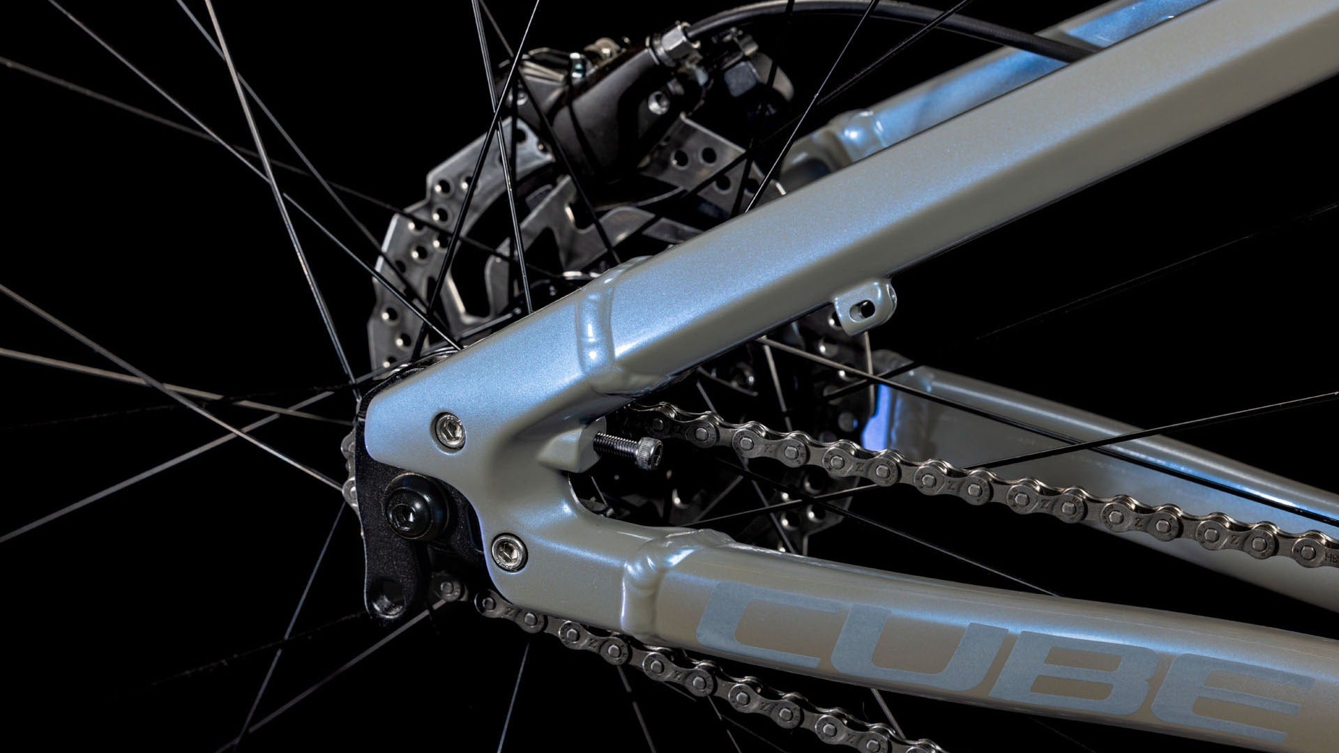 Close-up of a bicycle chain and gear system on a Cube bike on a black background