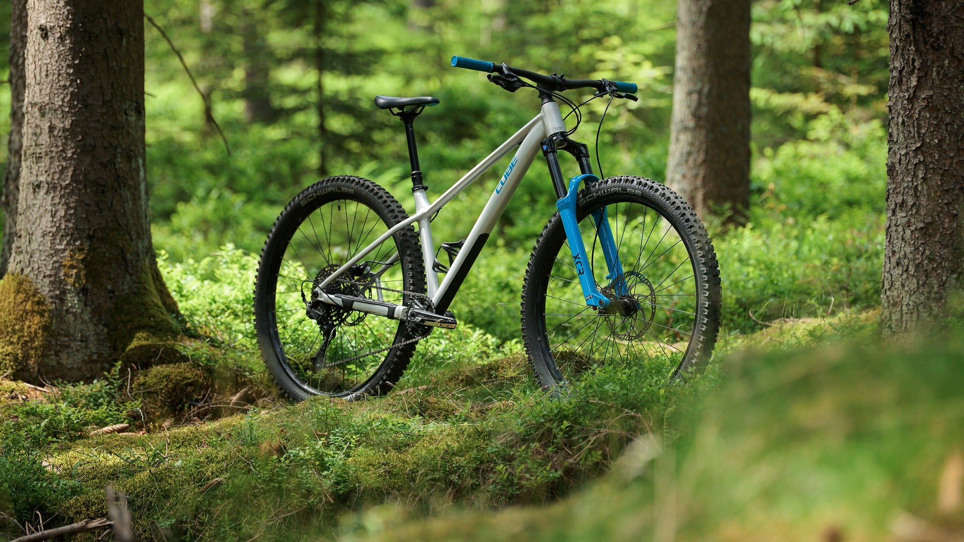 Silver and blue Cube mountain bike in a forest setting