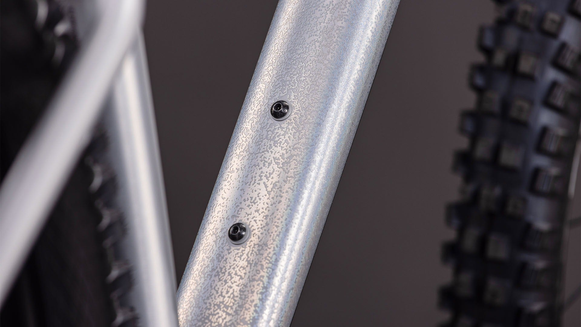 Close up of a silver mountain bike frame on a blurred background