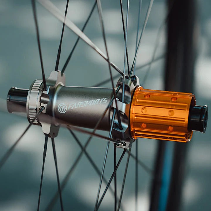 Close-up of a bicycle hub with an orange lock on a blurred background