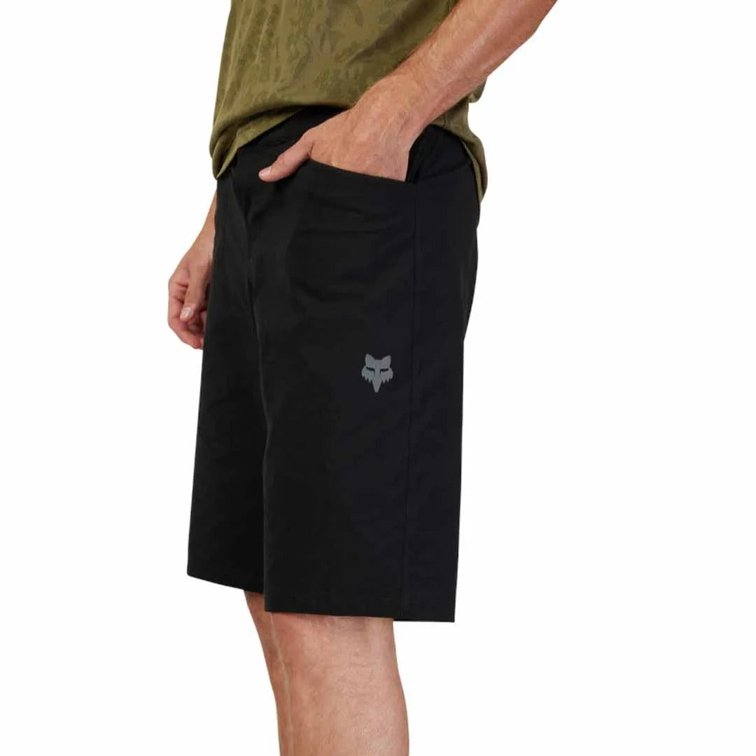 Person wearing black mountain bike shorts with a Fox logo on a white background