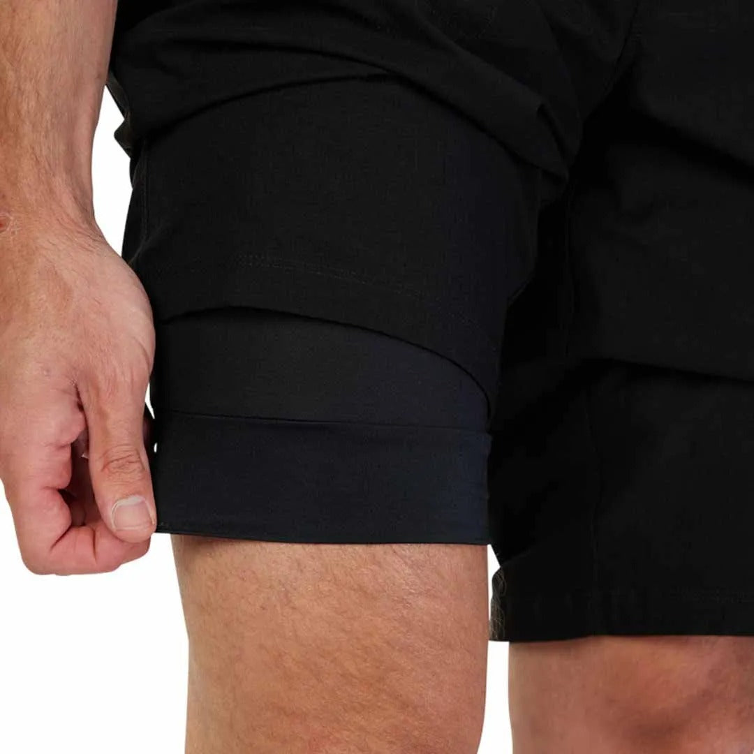Close-up of a person wearing black mountain bike shorts on a white background