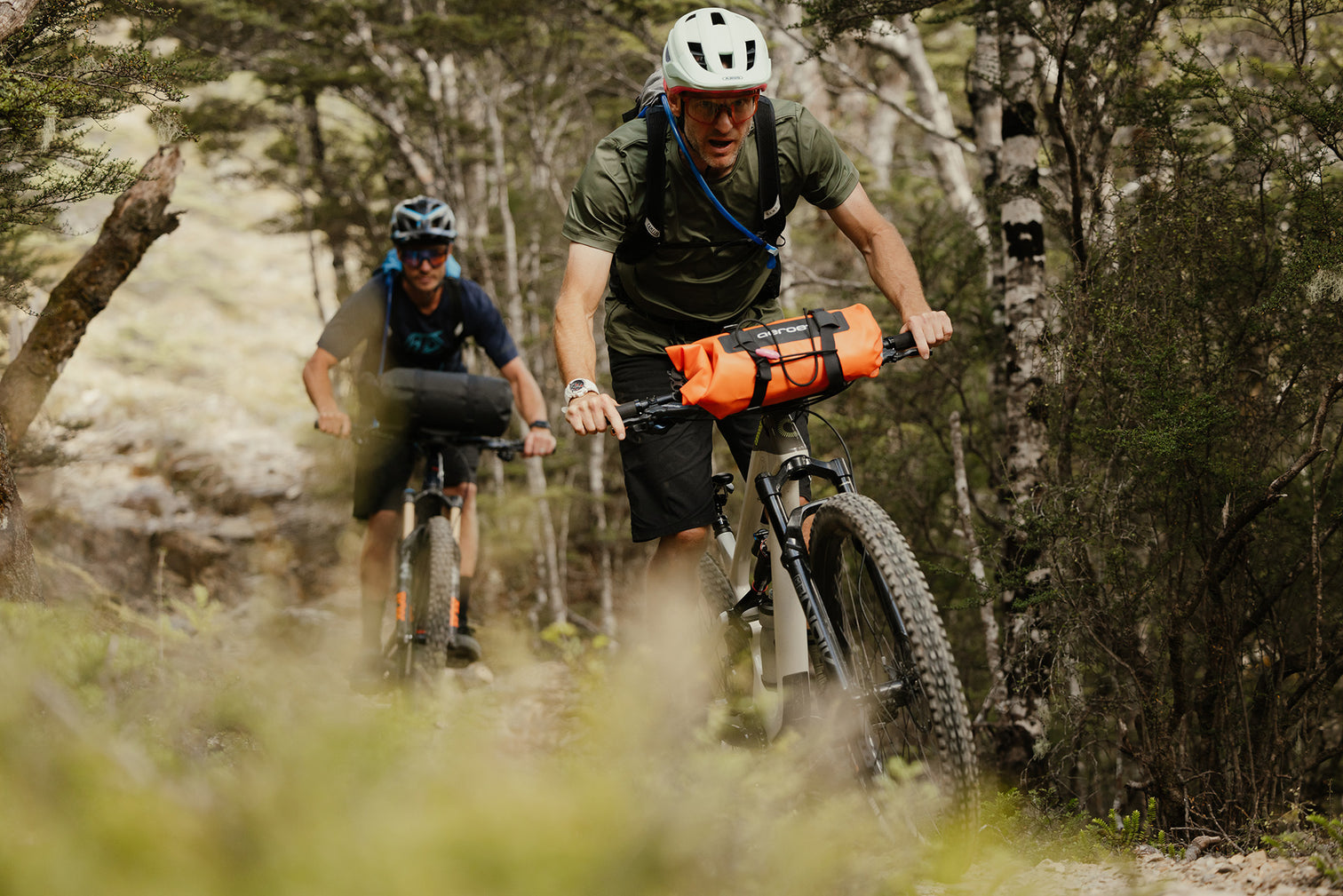 A picture of the Aeroe Spider Handlebar Cradle attached to the front of mountain bikes ridden by two blokes