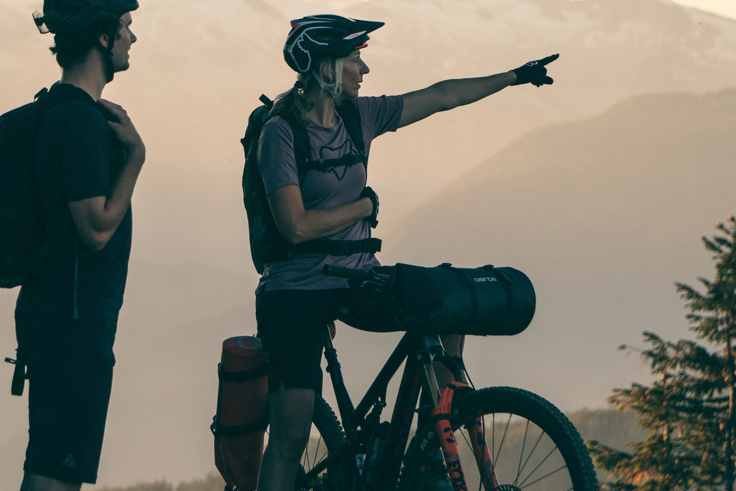 A picture of a lady on a bike with the Aeroe Spider Handlebar Cradle and bag attached to bike