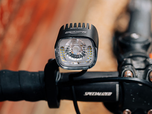 A picture of the MagicShine ME 1000 E-Bike Light attached to a handlebar of a bike