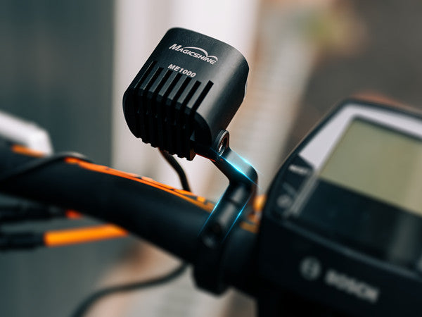 A picture of the MagicShine ME 1000 E-Bike Light attached to a bike and angled up.