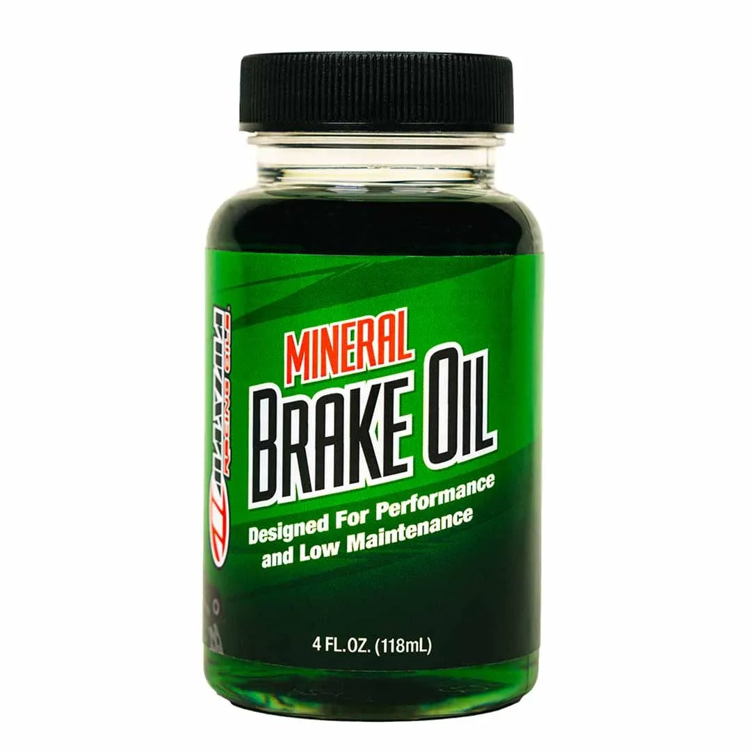 Bottle of mineral brake oil with green label and black cap on white background