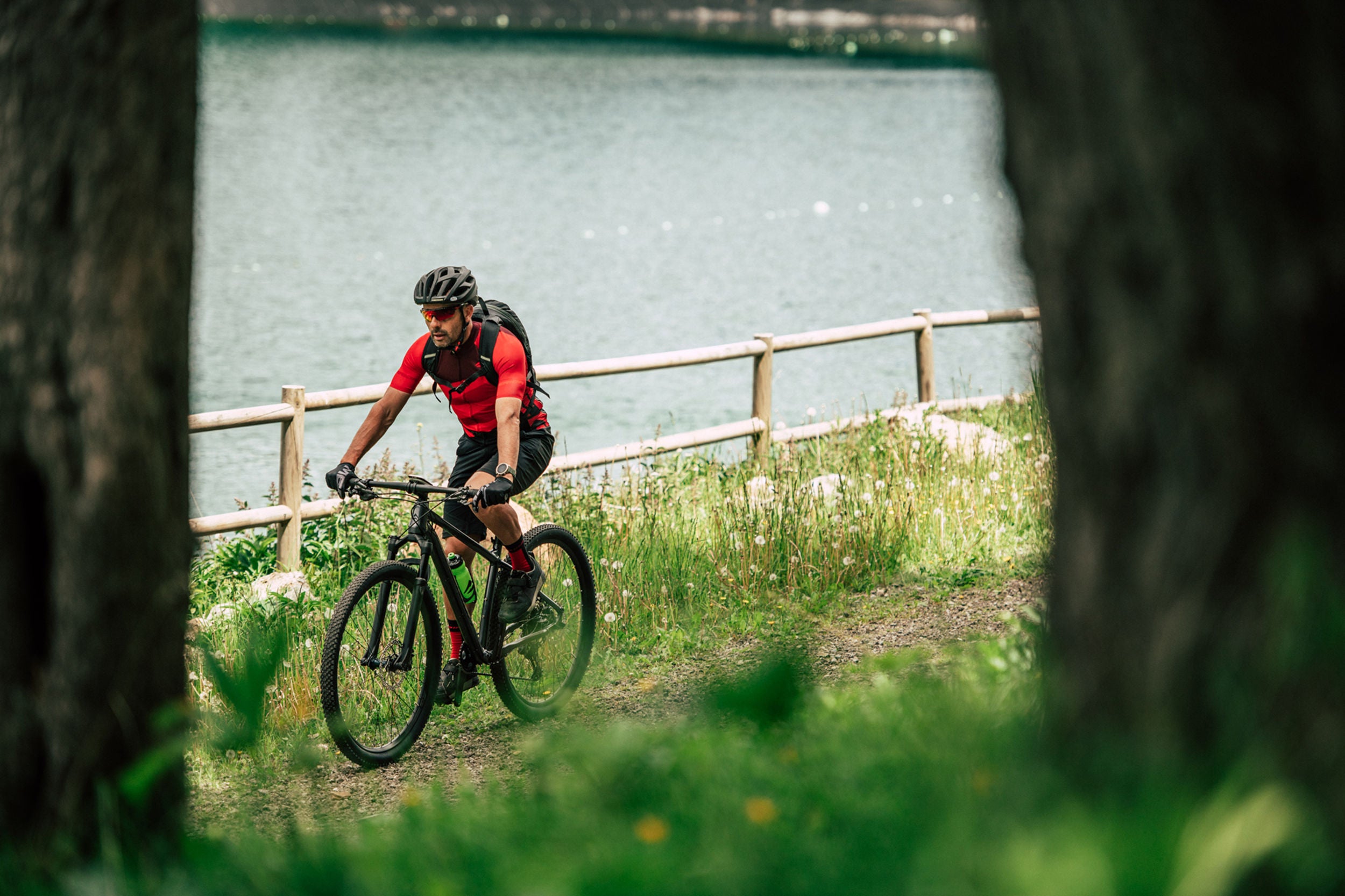 A picture of someone riding a Merida Big Nine mountain bike near a lake