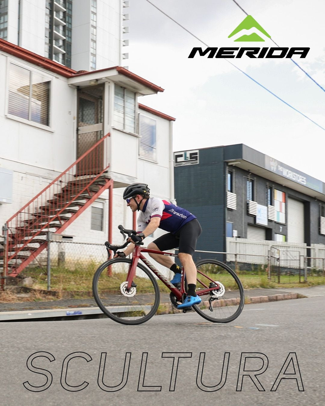 Cyclist riding a Merida Scultura bicycle on a street with buildings in the background