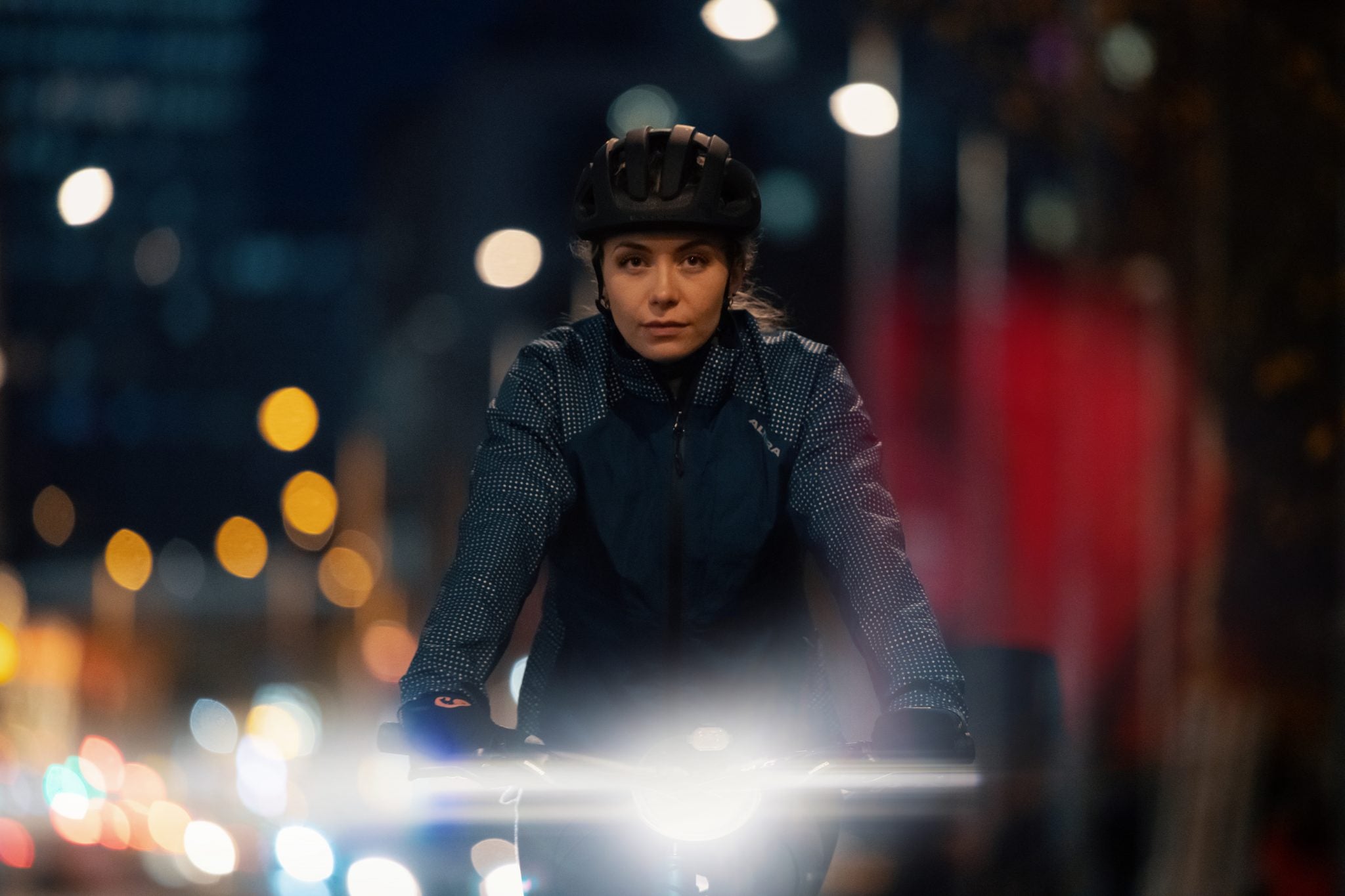 A person riding a bike at night with a bright front light attached