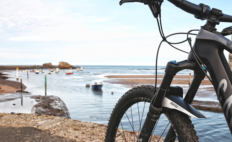 A picture of the Mucky Nutz Face Fender Mudguard fitted to a bike with ocean in background