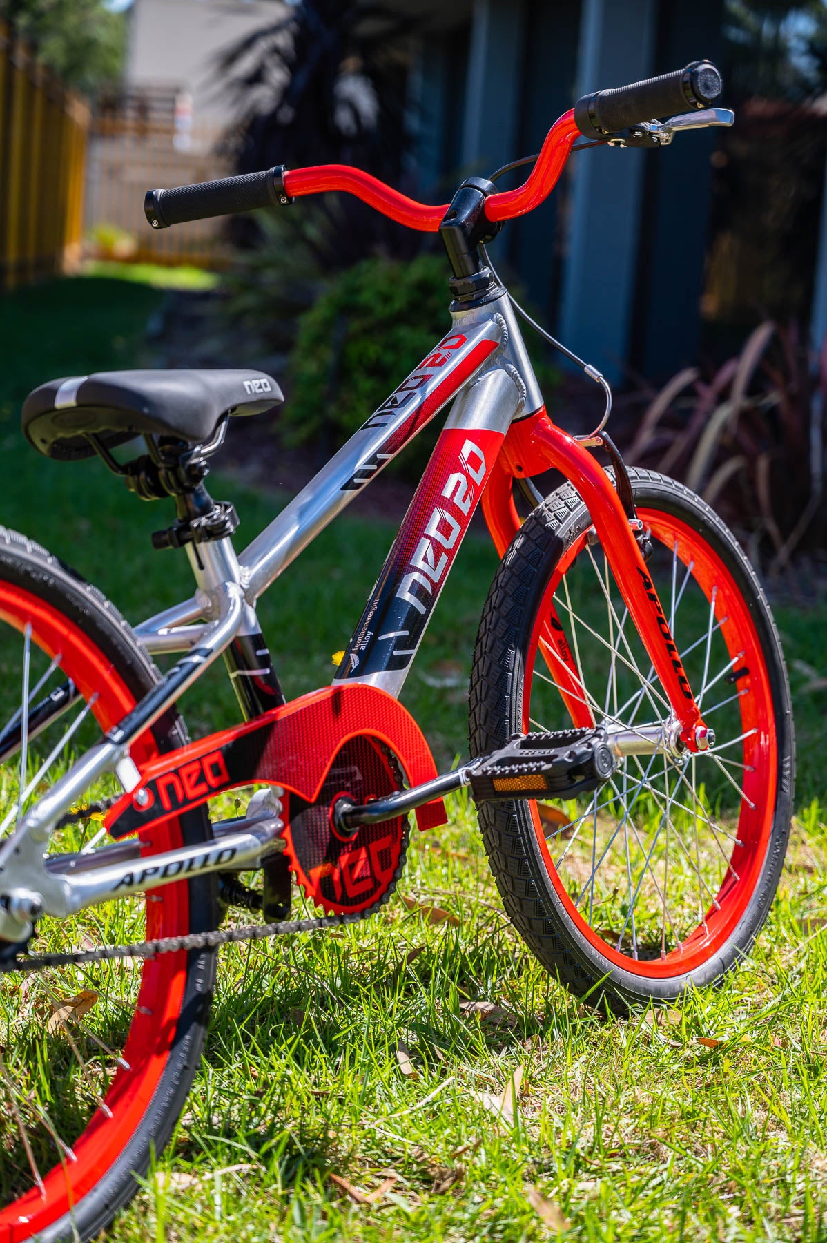 A picture of the black red Neo 20" Boys Bike on the grass