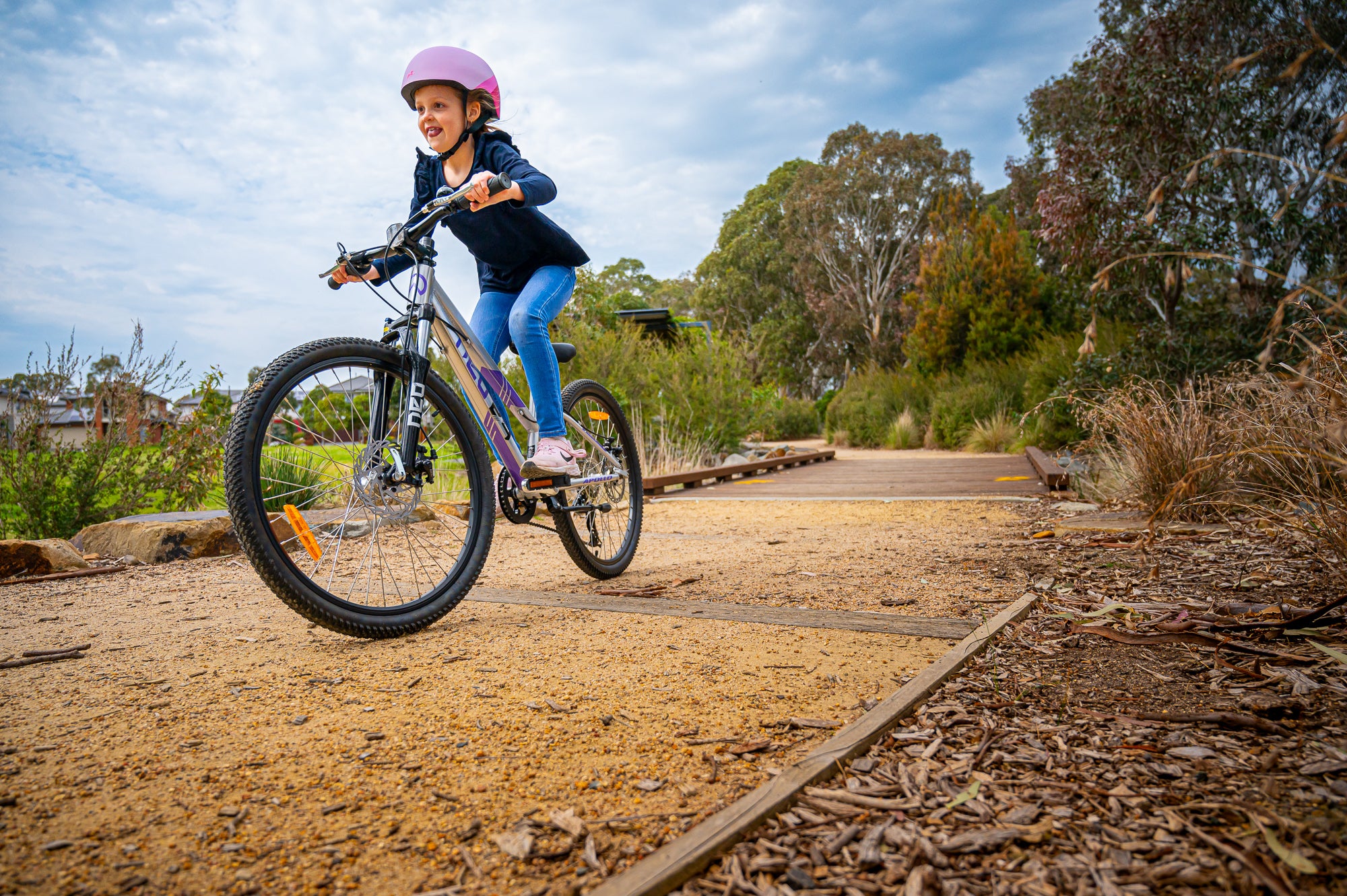 A picture of a girl riding the Neo Disc 24" Girls Bike