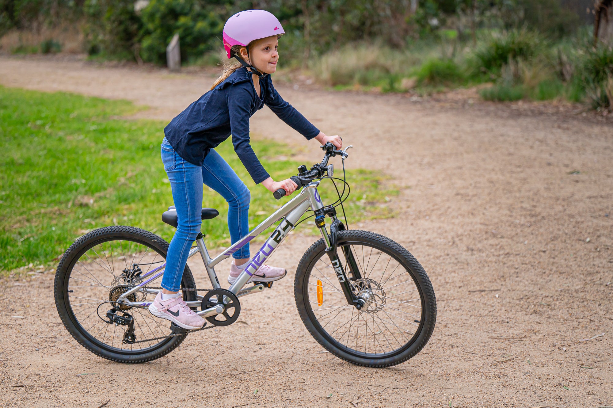 A picture of a girl riding the Neo Disc 24" Girls Bike