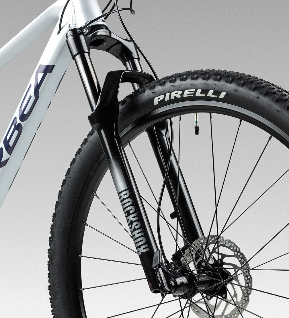 Close-up of a silver mountain bike wheel with Pirelli tyre on a white background