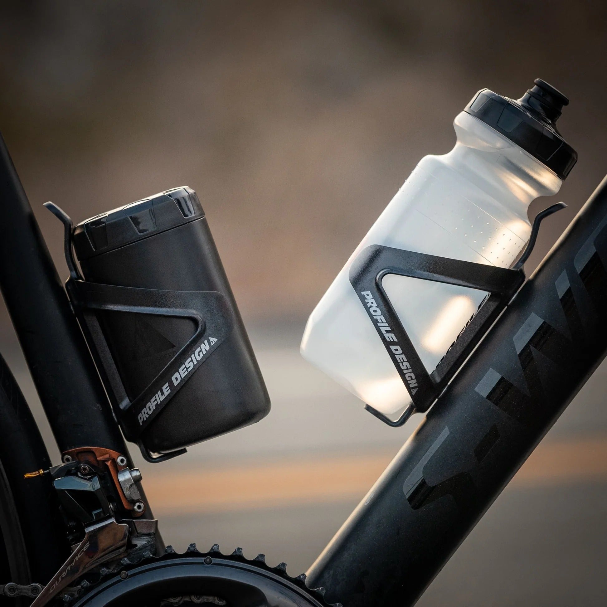Two bicycle water bottle holders with a water bottle in one and a tool bottle in the other on a blurred background