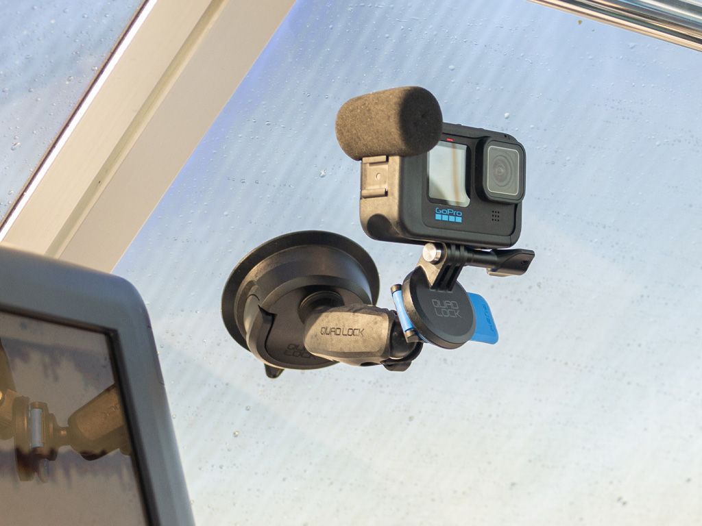 A GoPro Camera attached to a Quad Lock Mount on the windscreen of a car