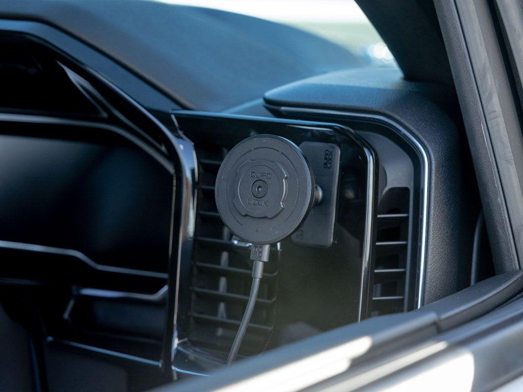 Car air vent with a Quad Lock magnetic phone holder attached inside a vehicle.