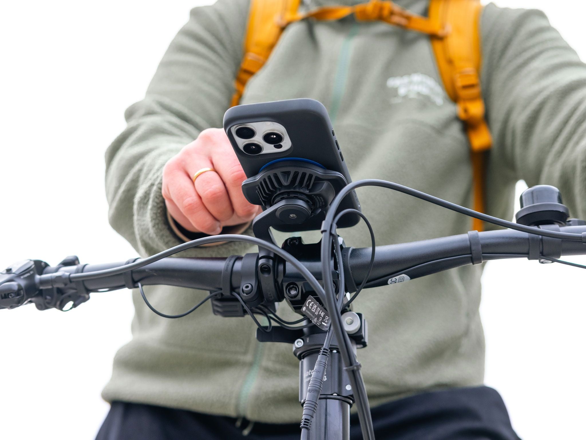Person holding a phone with a bike mount on a bicycle
