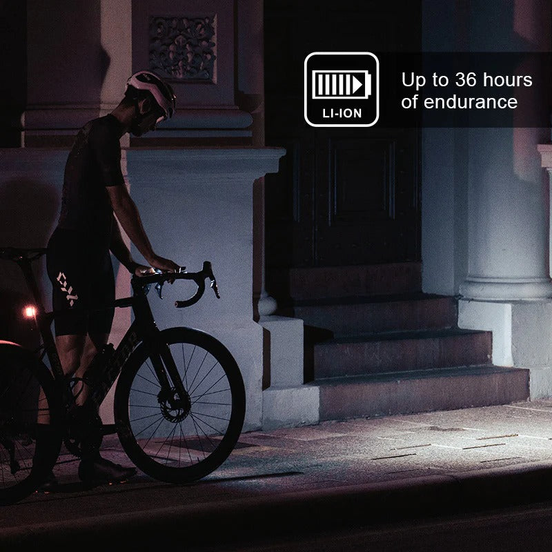 Person with a bicycle at night with a bright front light, with a focus on battery endurance text.
