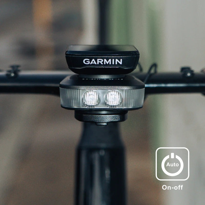 Garmin and Ravemen FR500 Front Bicycle Light attached to a road bike with a blurred background and 'Auto On-Off' displayed on picture