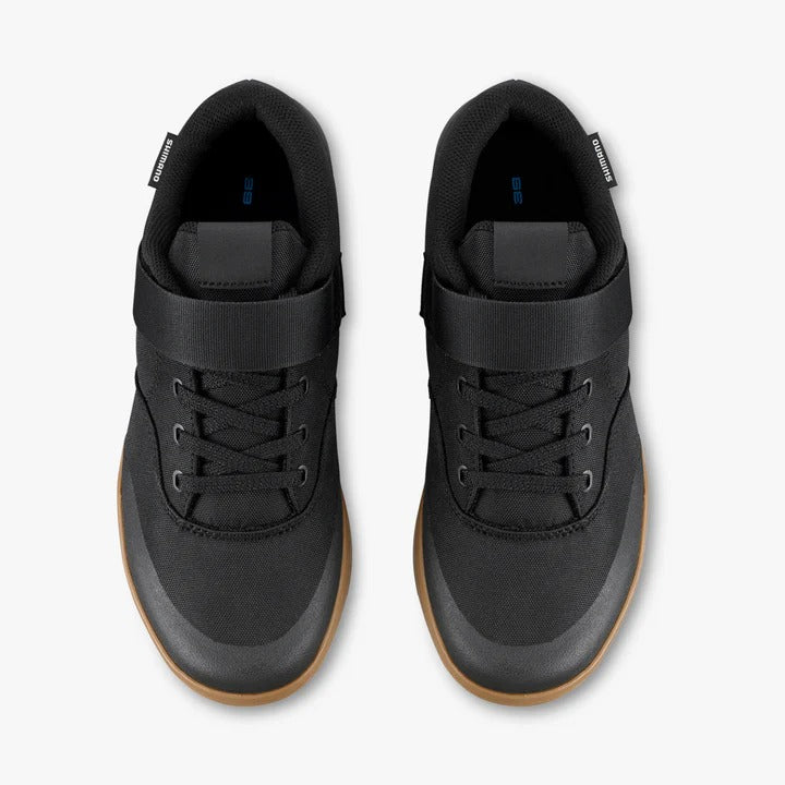 A pair of black mountain bike shoes against a white background