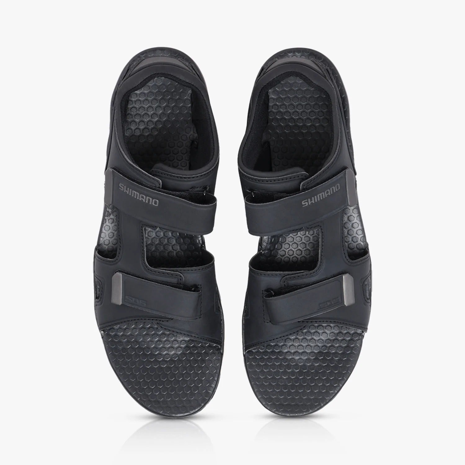 Pair of black cycling sandals with a textured sole on a white background