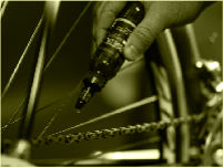 A picture of someone applying the Silca Super Secret Chain Lube onto a bicycle chain