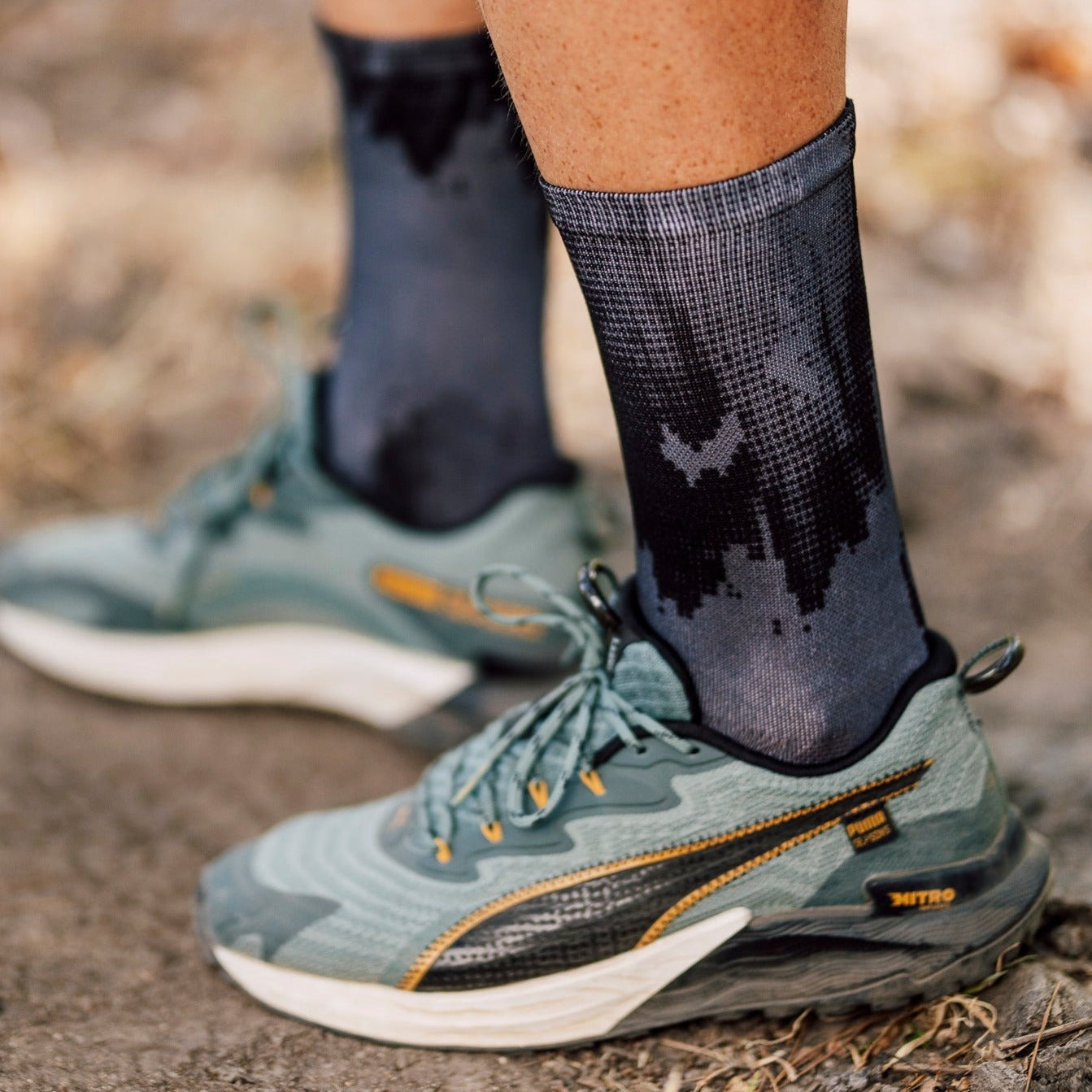 A picture of someone wearing trainers and the Sox Black Gravel Socks