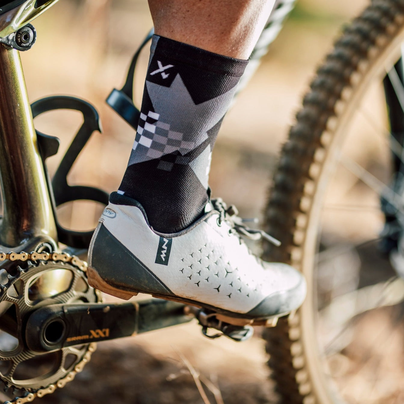 A picture of someone wearing the Sox X Black Cycling Socks while riding a mountain bike