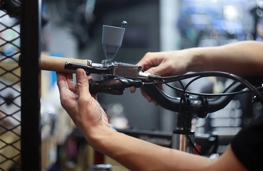 A picture of someone bleeding a Tektro Brake Kit on a bike