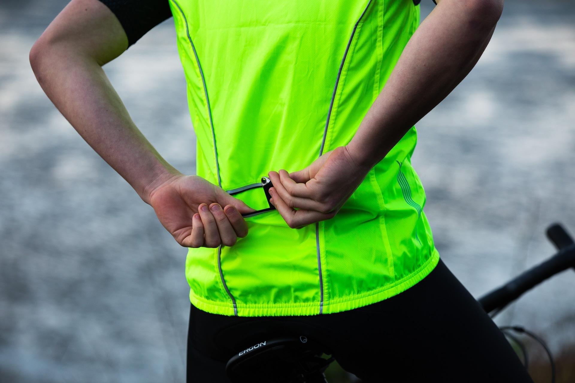 Person wearing a bright green reflective safety vest with blurred background