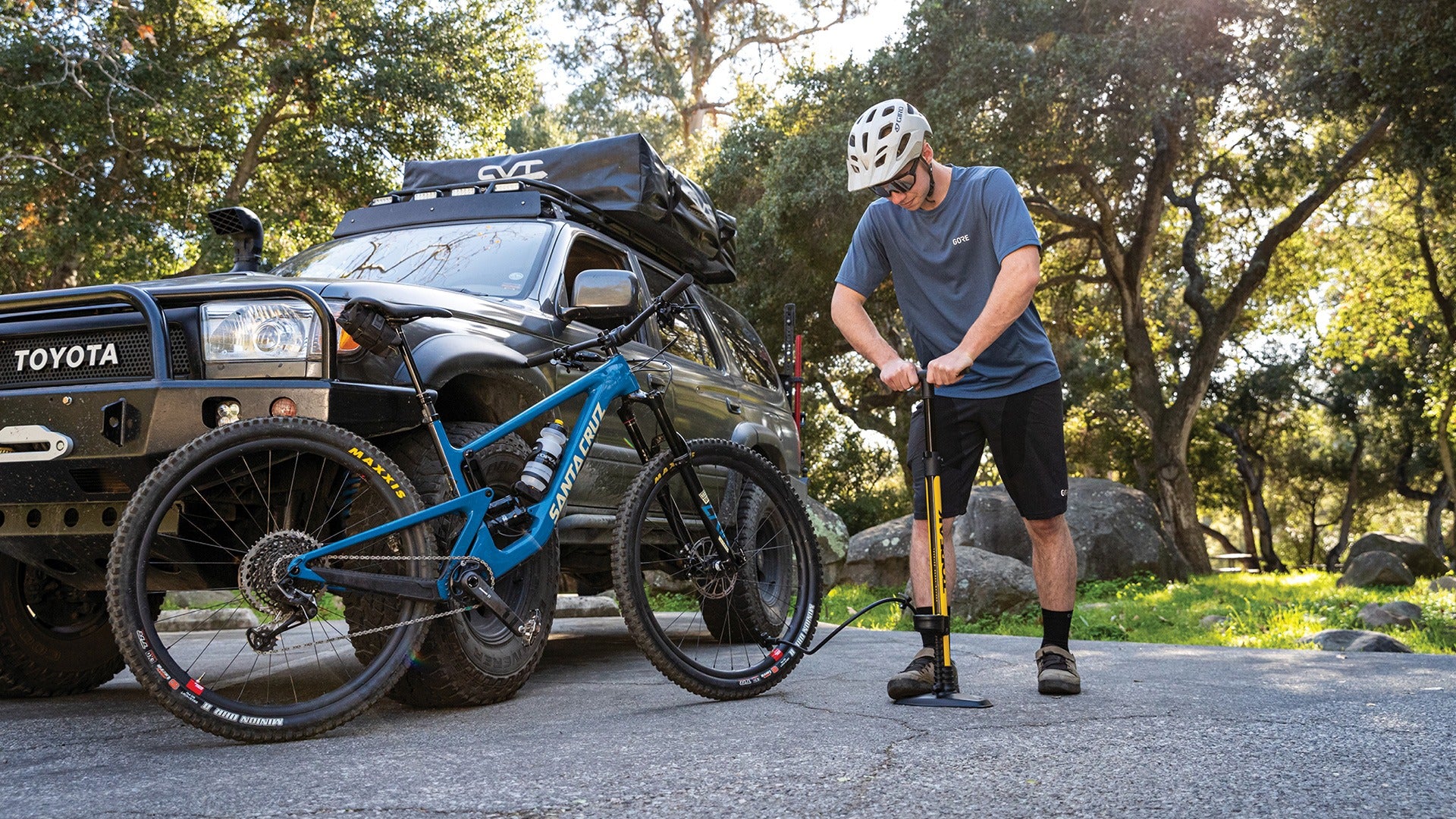 A person pumping tyres of mountain bike outside using a bicycle floor pump
