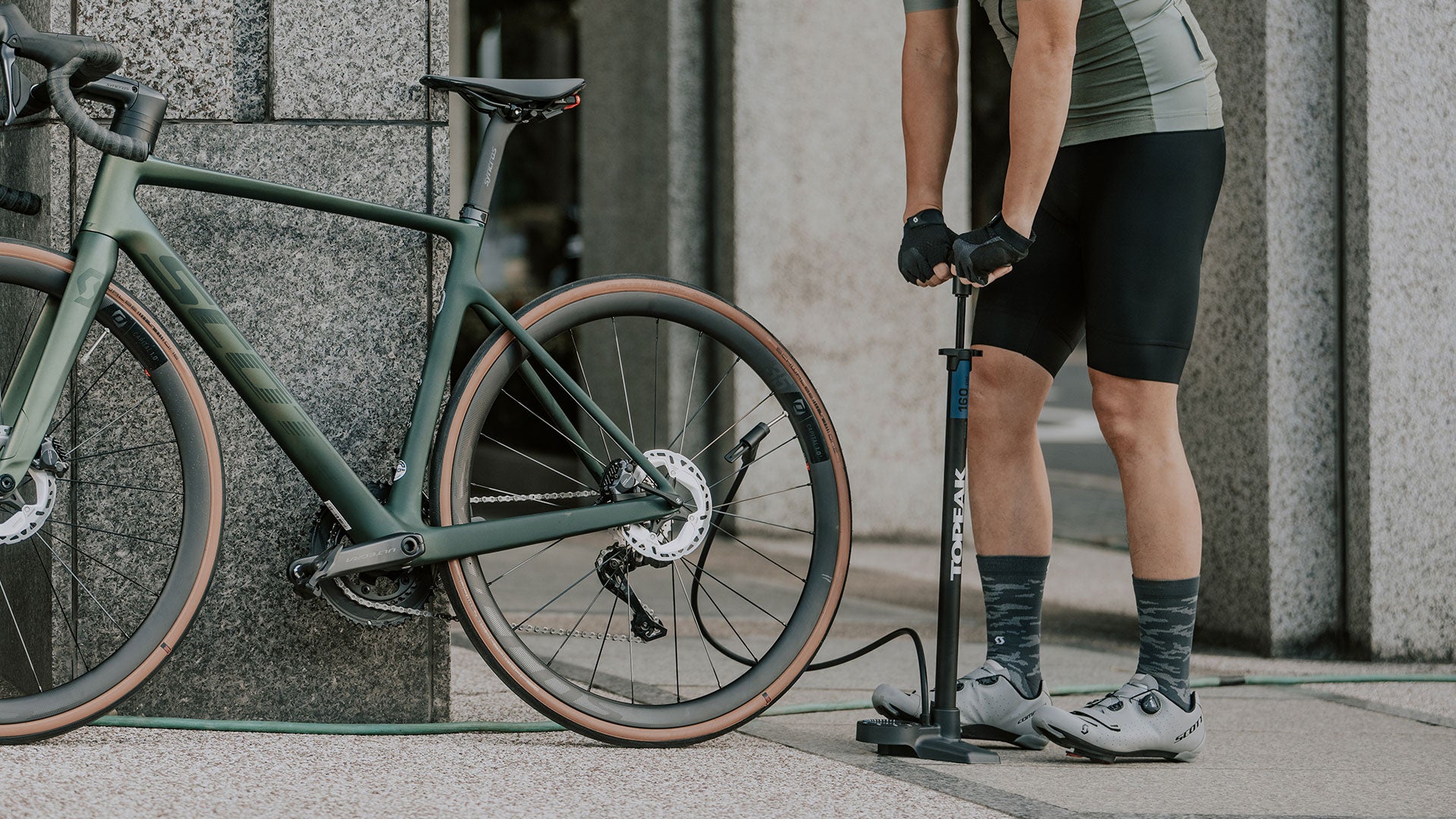 A picture of a man pumping up his tyres using the Topeak Jowblow Roadie Pump