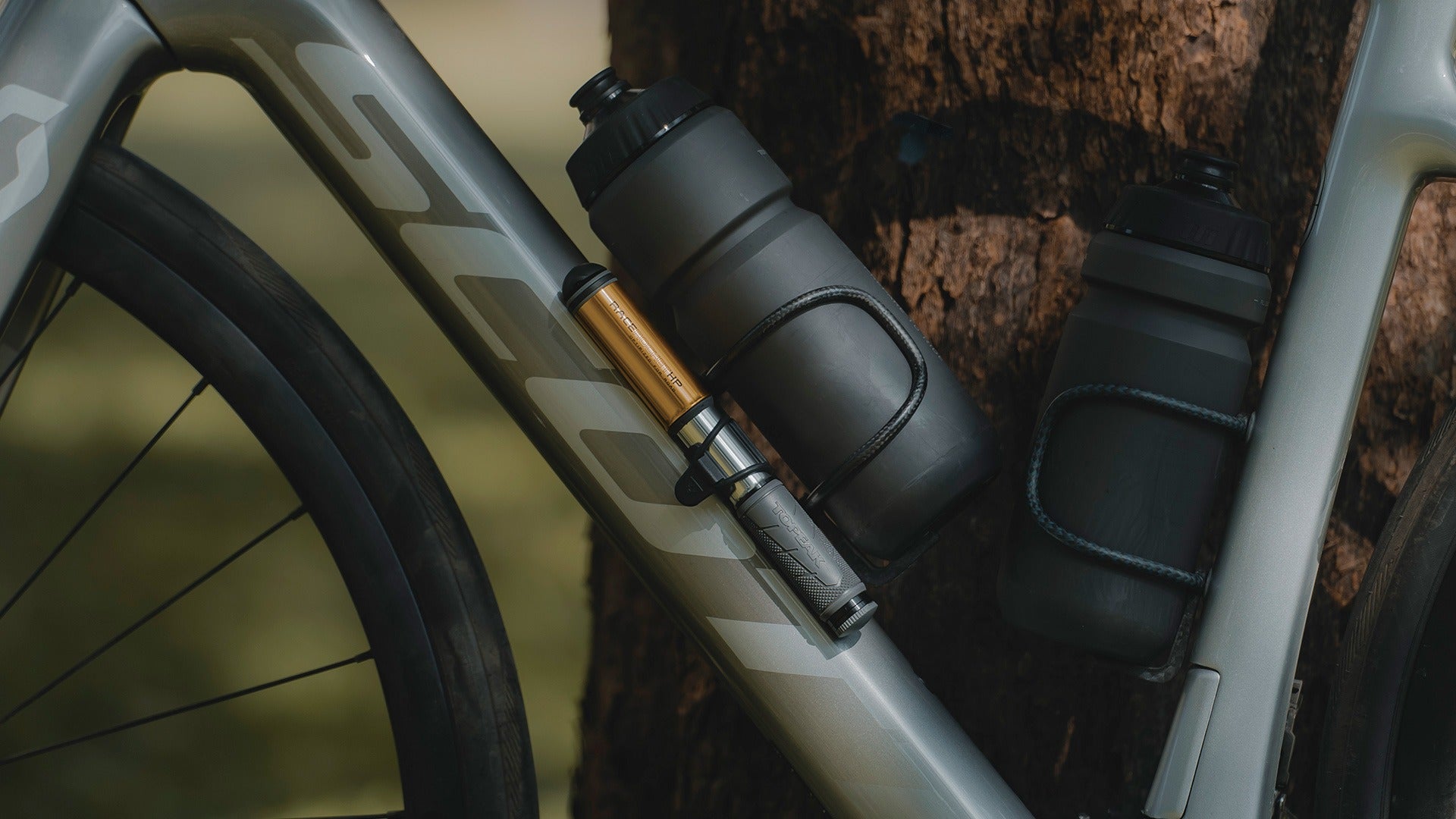 A close up of a bicycle pump attached to a Scott Bike leaning against a tree