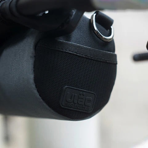 A close up of a black handlebar bag from the side attached to a bike
