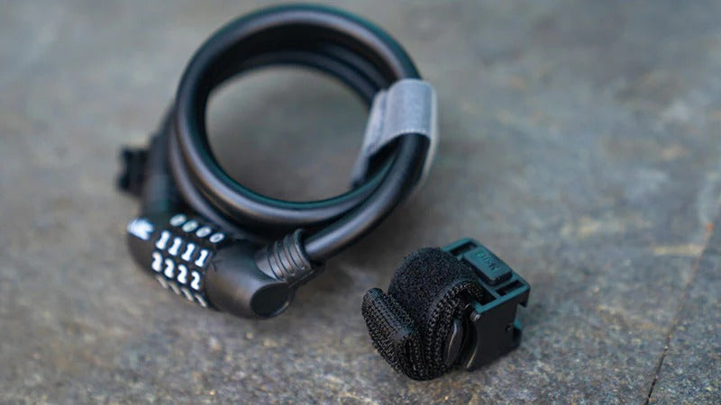 Black bike lock with a combination lock on a gray surface
