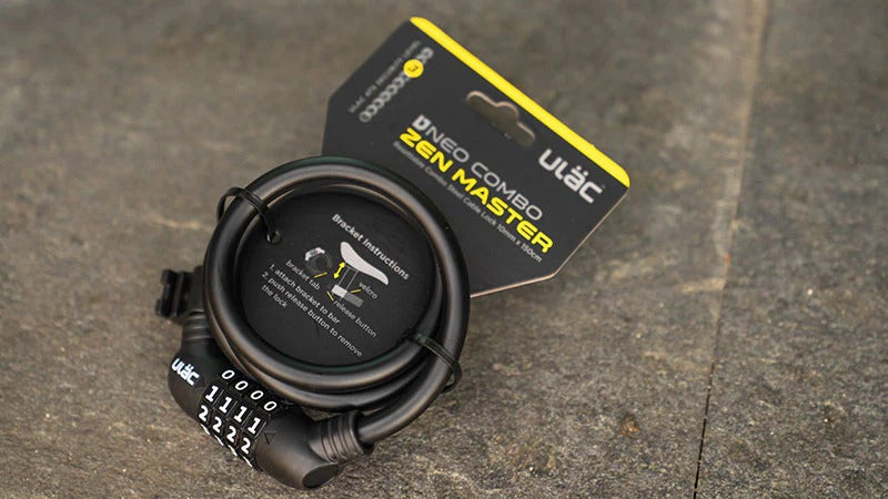 Black bike lock with a ULAC packaging on a concrete surface