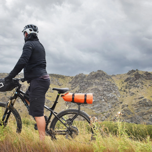 A picture of a guy on a bike with the Aeroe Spider Rear Bicycle Rack attached to his bike