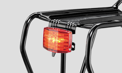 A picture of a rear light attached to the Topeak Uni Super Tourist DX (Disc) 24-29" Pannier Rack