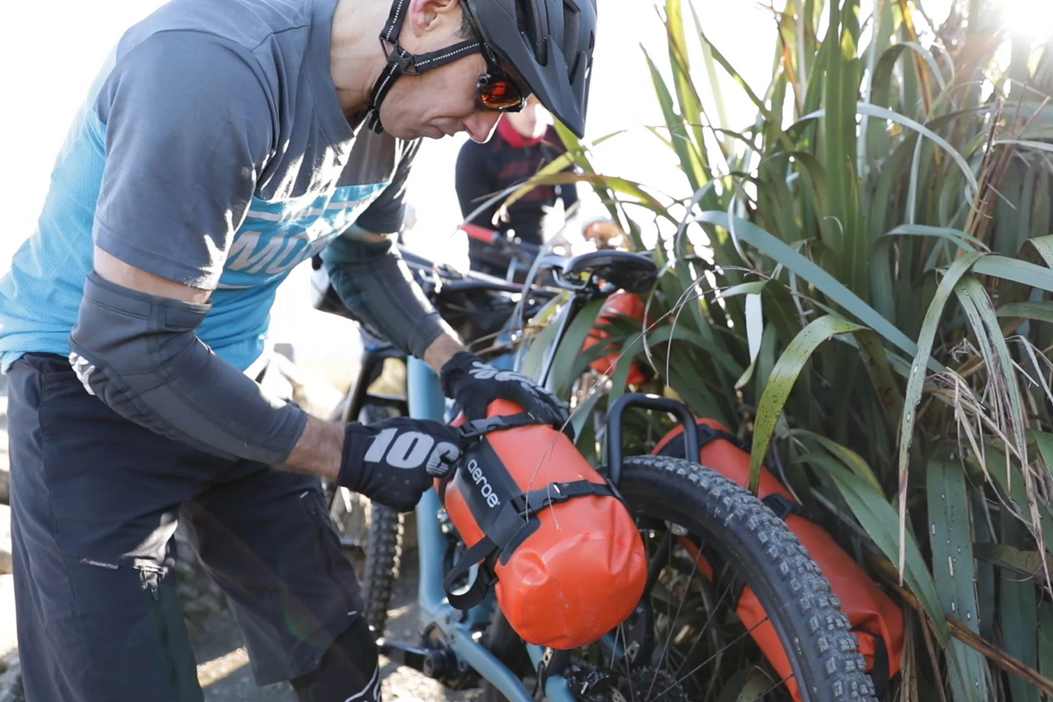 A picture of someone attached bags into the Aeroe Spider Rear Cradle on the rear bike rack