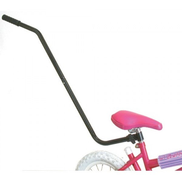 Pink children's bicycle with black training handle attached to the seat post of the bike on a white background