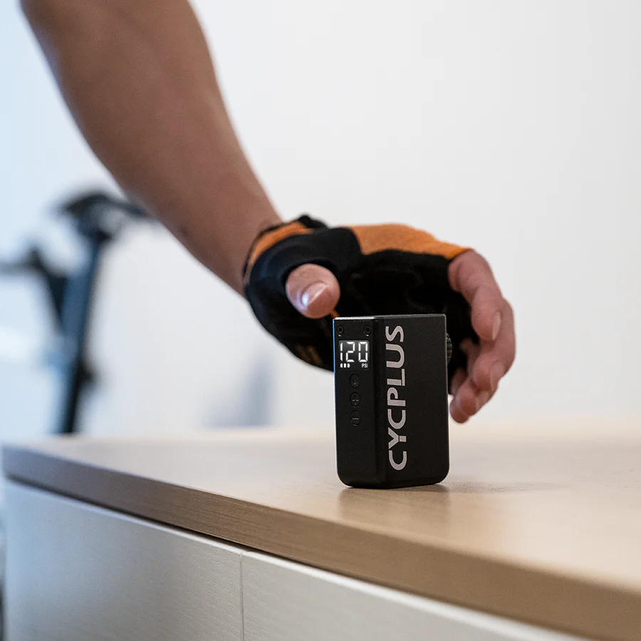 Person holding a CyclusPlus electric bike pump on a counter