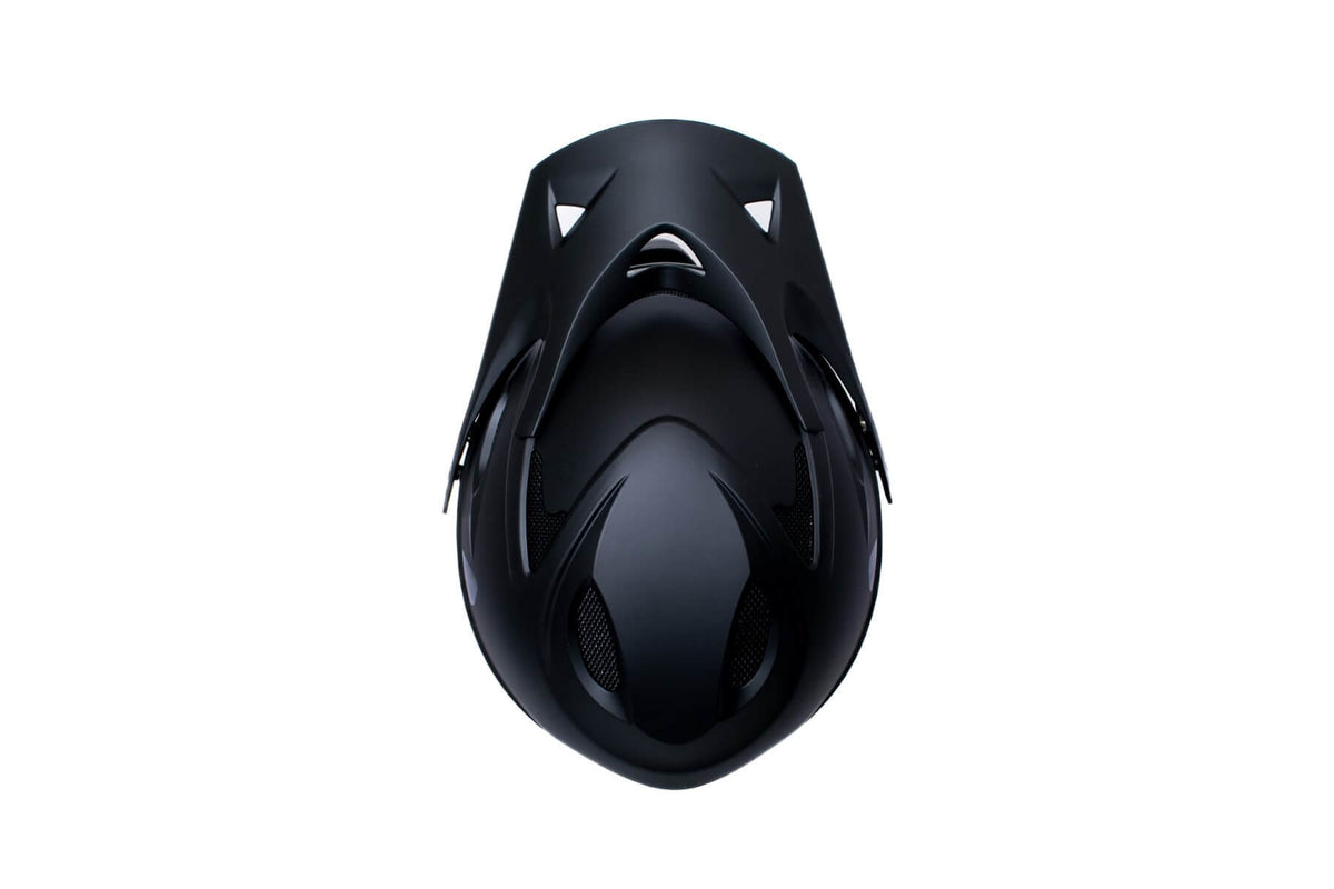 Birds eye view of a black full face mountain bike helmet on a white background
