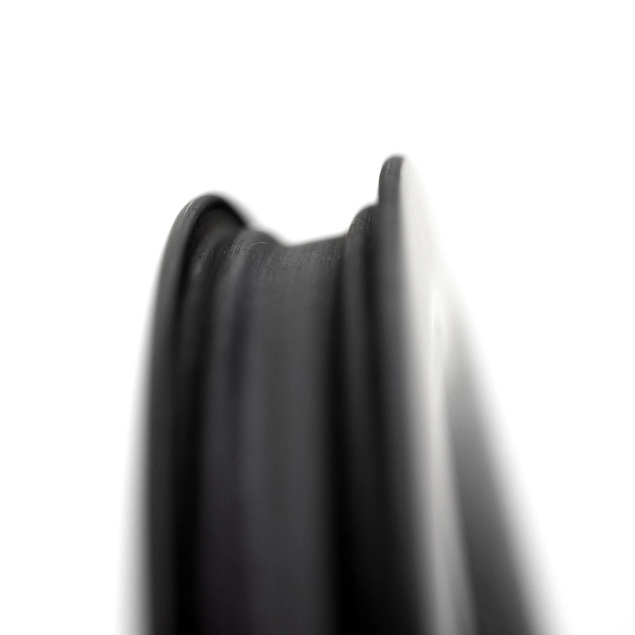 Close-up of a black bicycle rim on a white background