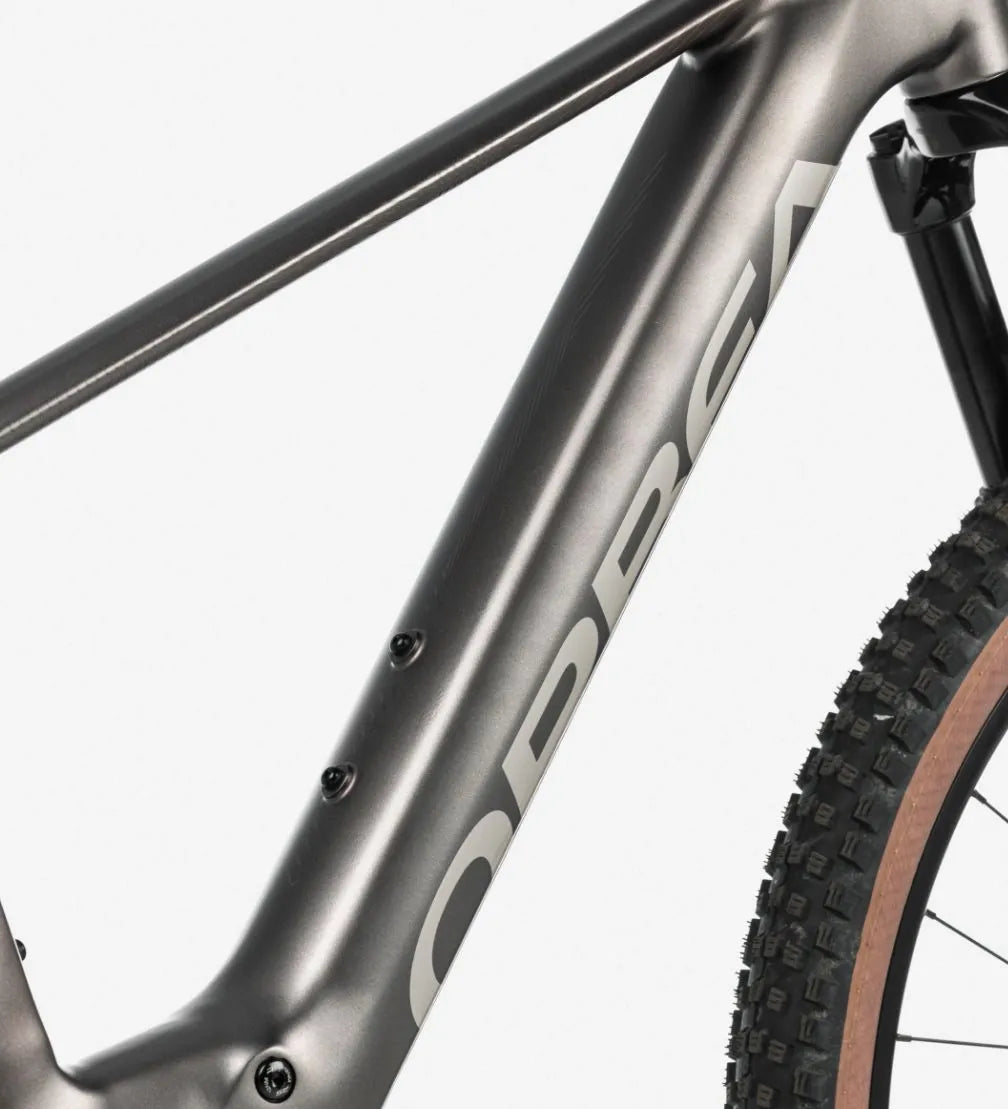Close-up of a silver bicycle frame with 'Orbea' branding on a white background