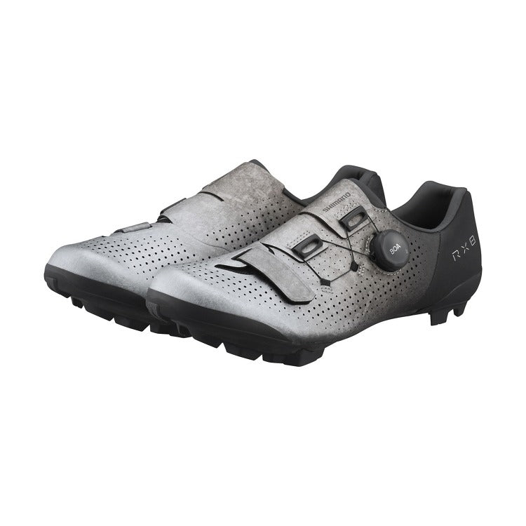 Pair of silver mountain bike cycling shoes with black soles on a white background