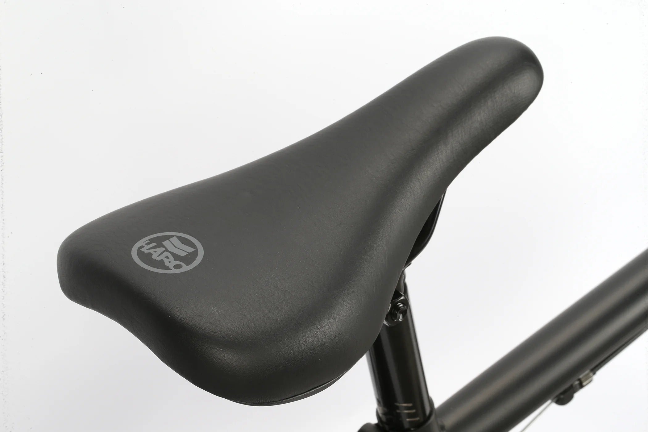 Close-up of a black Haro BMX bicycle seat with a brand logo on a white background
