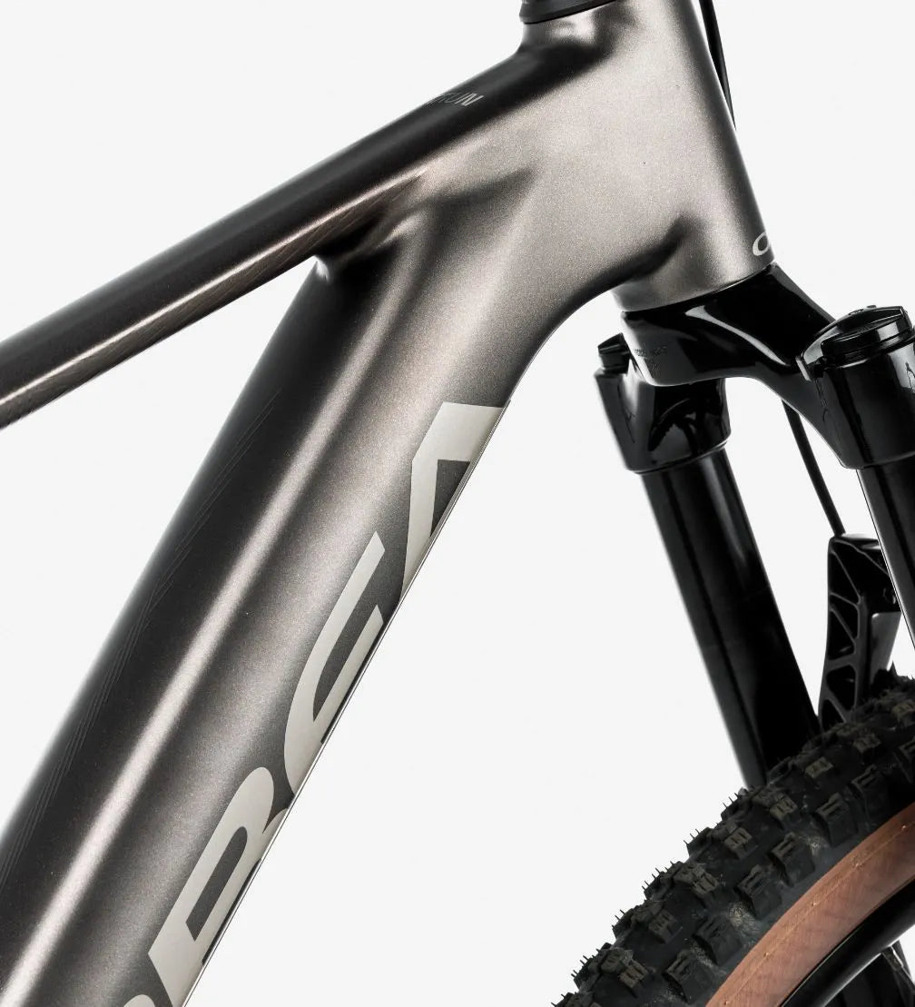 Close-up of a silver bicycle frame with 'Orbea' branding on a white background